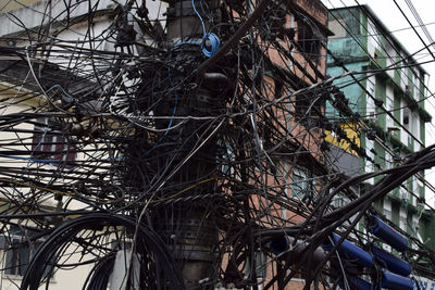 Low angle view of bare tree against buildings