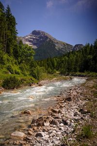 Scenic view of river amidst mountains against sky