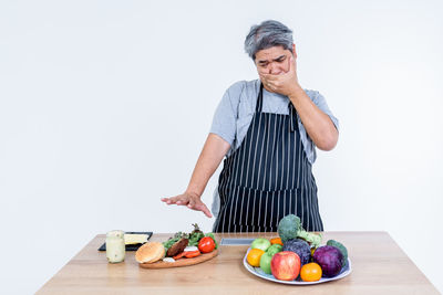 Man preparing food on table against white background