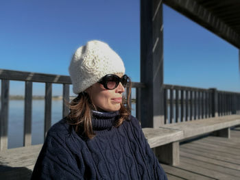 Young woman in sunglasses sitting outdoors