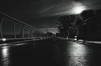 Bridge over road in city against sky at night