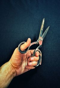 Close-up of cropped man holding scissors