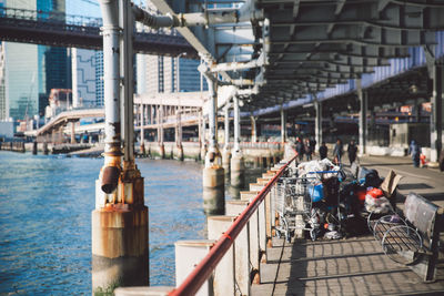 Shopping carts by railing on walkway below elevated road in manhattan