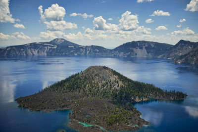 Scenic view of lake by mountains against sky