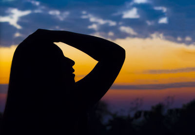 Silhouette woman against sky during sunset