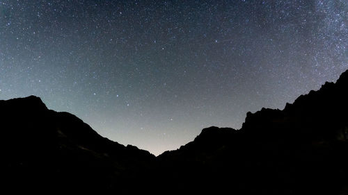 Sky full of stars above alpine valley with mountains silhouettes, slovakia, europe