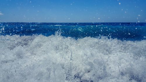 Wave rushing towards shore against sky