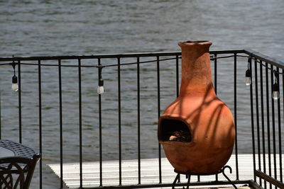 Close-up of metal railing against sea