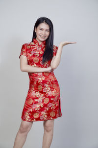 Portrait of a smiling young woman against white background