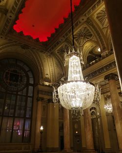 Low angle view of illuminated chandelier hanging against sky