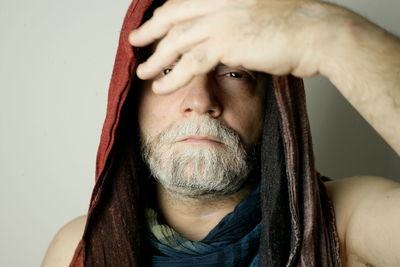 Close-up portrait of man wearing hood against white background