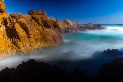 Scenic view of sea and mountains against sky