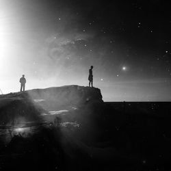 Silhouette of people standing in water