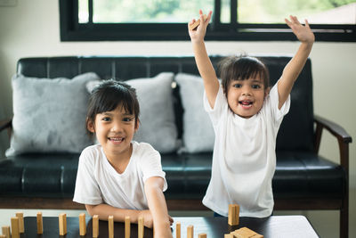 Portrait of siblings playing with toy blocks on table