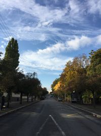 Road amidst trees against sky