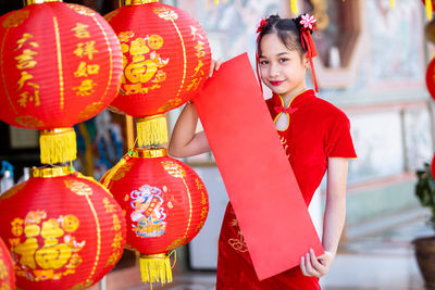 Full length of woman standing by red lanterns