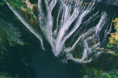 Aerial photo of beautiful wild waterfalls cut into the cliffs overgrown with tropical vegetation. 