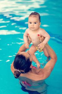 Mother and son swimming in pool