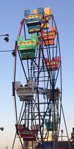 Low angle view of ferris wheel against clear blue sky