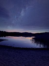 Scenic view of lake against sky at night