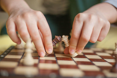 Midsection of man playing chess on table