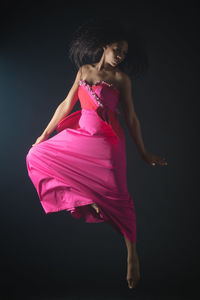 Beautiful woman standing against black background