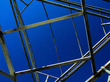 Low angle view of metallic structure against blue sky