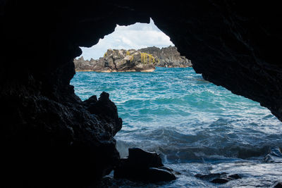 Rock formation in sea against sky