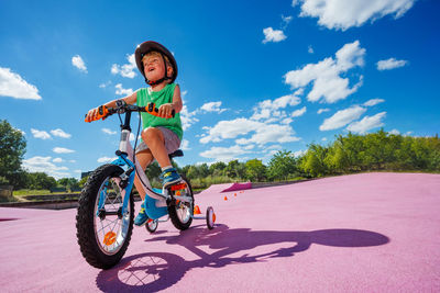 Portrait of boy riding bicycle on road