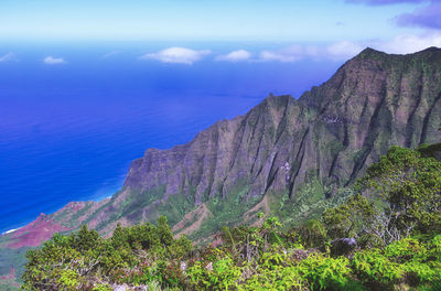 Scenic view of mountain by sea against sky