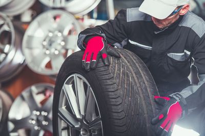 Mechanic looking at tire in garage