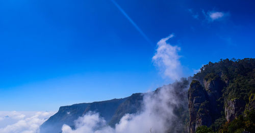 Low angle view of mountain against blue sky