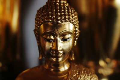 Close-up of gold buddha statue in temple