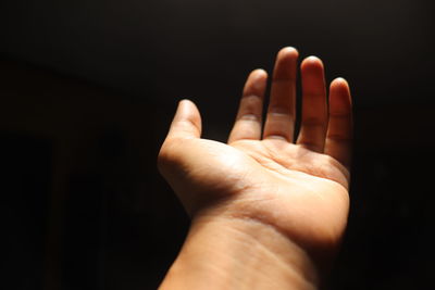 Close-up of hand against black background