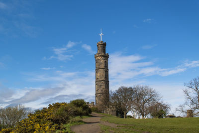 Low angle view of calton hill's tower against blue sky in edinburgh