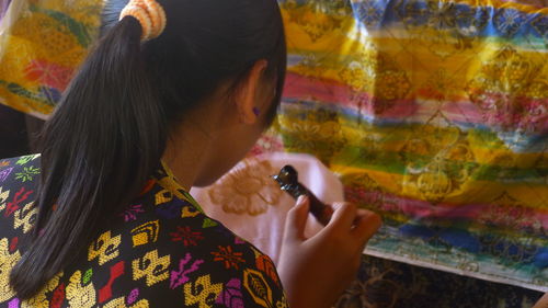 Woman applying design on fabric 