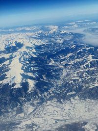 Aerial view of snowcapped mountains against sky