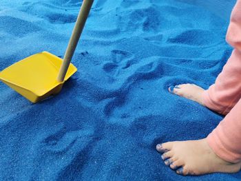 Low section of child legs on sand