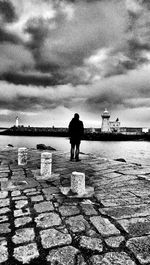 People in water against cloudy sky