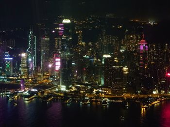 Illuminated buildings by river at night