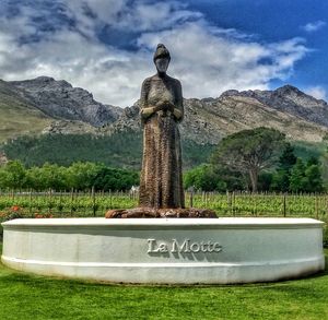 Statue against trees and mountains against sky