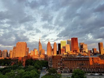 Buildings in city against cloudy sky