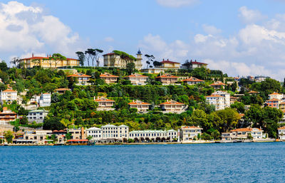 View of residential district by sea against sky