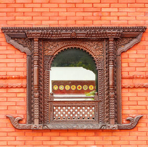 Beautifull window in red brick wall of a public buddhist temple in china