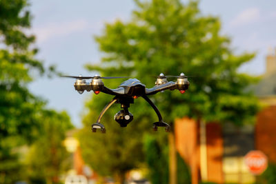 Drone flying against trees