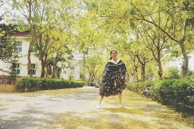 Full length of woman standing on tree trunk