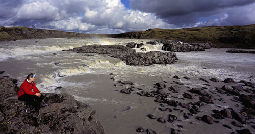 Woman admiring waterfall on the river Þjórsá in iceland