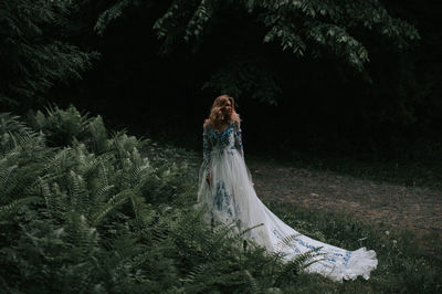 Bride standing by plants