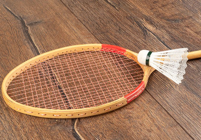 Selective focus. white badminton shuttlecock on a wooden badminton racket on a wooden background.