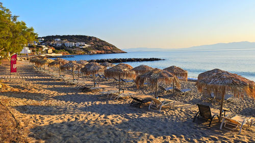 Sandy beach with umbrellas and sunbeds by the blue sea.